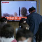Ľudia sledujú televízne správy o odpálení neidentifikovaného projektilu zo strany Severnej Kórey na železničnej stanici v Soule v stredu 4. mája 2022.
