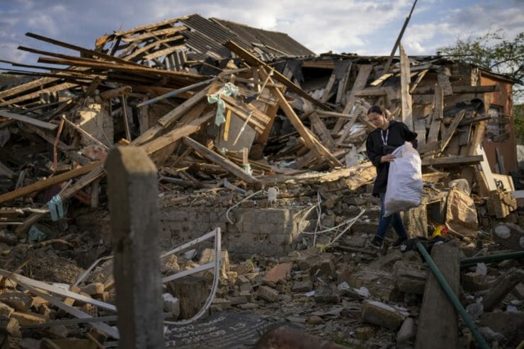 Na snímke 35-ročná Anna Ševčenková zachraňuje veci zo svojho domu zničeného bombardovaním v ukrajinskom meste Irpiň 3. mája 2022.