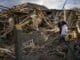 Na snímke 35-ročná Anna Ševčenková zachraňuje veci zo svojho domu zničeného bombardovaním v ukrajinskom meste Irpiň 3. mája 2022.