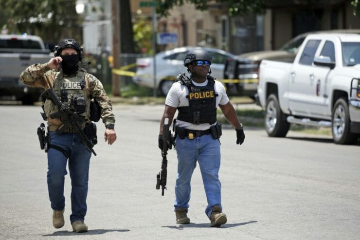 Policajti kráčajú po streľbe pred základnou školou Robb Elementary School v meste Uvalde v americkom štáte Texas 24. mája 2022.