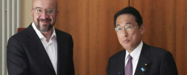 Predseda Európskej rady Charles Michel (vľavo) si podáva ruku s japonským premiérom Fumiom Kišidom.