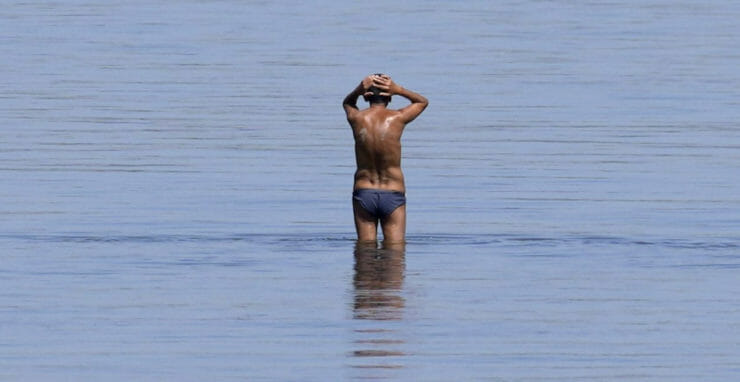 Na snímke muž sa ochladzuje na pieskovisku v Dunaji v srbskom Belehrade 22. júla 2022.