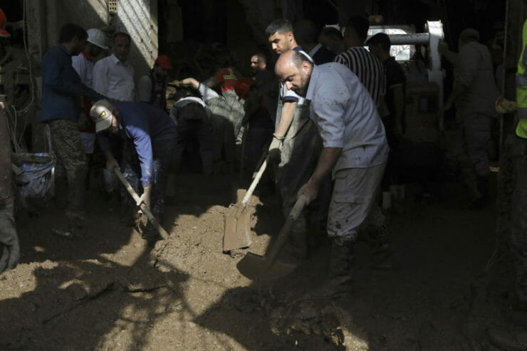 Záchranári a miestni obyvatelia odstraňujú bahno po prívalových povodniach v dedine ležiacej severozápadne od metropoly Teherán vo štvrtok 28. júla 2022.