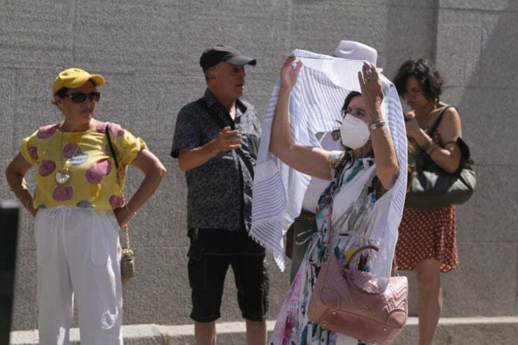 Žena sa zakrýva šatkou počas horúčav v Madride 16. júla 2022.