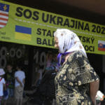 Ukrajinka prechádza pri nápise Centrum pomoci SOS Ukrajina 2022 v košickom Starom Meste, archívna snímka.