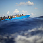 Skupina afrických migrantov sa plaví na drevenej loďke, archívna snímka.
