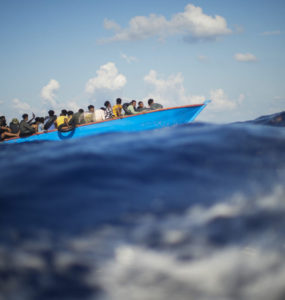 Skupina afrických migrantov sa plaví na drevenej loďke, archívna snímka.