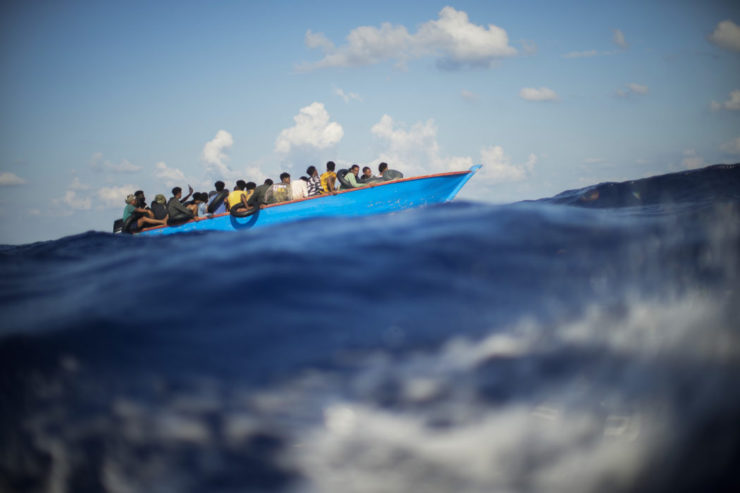 Skupina afrických migrantov sa plaví na drevenej loďke, archívna snímka.