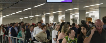 Na archívnej snímke z 21. júna 2022 cestujúci čakajú v rade na amsterdamskom letisku Schiphol.