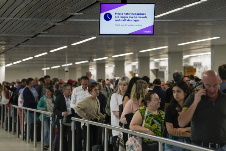 Na archívnej snímke z 21. júna 2022 cestujúci čakajú v rade na amsterdamskom letisku Schiphol.
