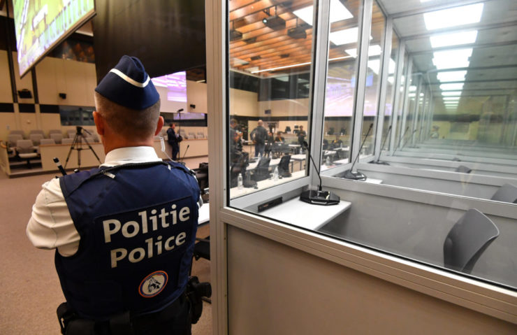 Policajt stojí pri presklenných kabínkach pre obvinených v súdnej sieni pred začiatkom úvodného vypočutia s obvinenými v kauze teroristických útokov z roku 2016 v Justičnom paláci v Bruseli 12. septembra 2022.