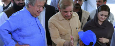 Šéf OSN António Guterres (v modrej košeli) a pakistanský premiér Šehbáz Šaríf (v béžovej košeli) sa zhovárajú s deťmi v škole, ktorá slúži ako tábor pre ľudí postihnutých záplavami v Jaffarabade 10. septembra 2022.