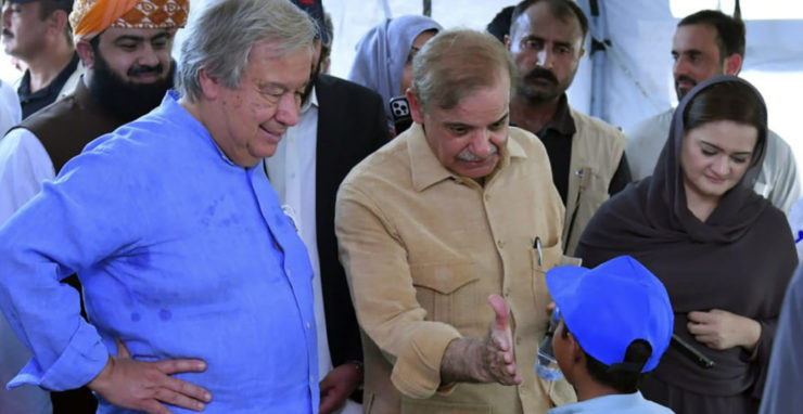 Šéf OSN António Guterres (v modrej košeli) a pakistanský premiér Šehbáz Šaríf (v béžovej košeli) sa zhovárajú s deťmi v škole, ktorá slúži ako tábor pre ľudí postihnutých záplavami v Jaffarabade 10. septembra 2022.