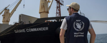 Pracovník Svetového potravinového programu OSN stojí pri lodi MV Brave Commander, ktorá prepravila obilie z ukrajinského čiernomorského prístavu Pivdennyj do prístavného mesta Džibuti v utorok 30. augusta 2022.