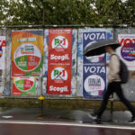 Muž kráča okolo predvolebných bilbordov politických strán v Miláne v sobotu 24. septembra 2022.