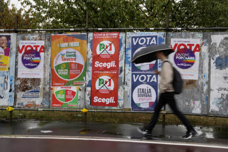 Muž kráča okolo predvolebných bilbordov politických strán v Miláne v sobotu 24. septembra 2022.