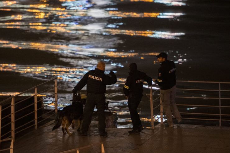 Policajti na lodi prehľadávajú nábrežie Dunaja po streľbe na Zámockej ulici v Bratislave 12. októbra 2022.
