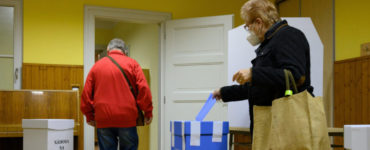 volička vhadzuje obálku s hlasovacími lístkami do volebnej schránky pre voľby do VÚC