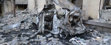 Zničené auto neďaleko administratívnej budovy po ostreľovaní v Donecku na východe Ukrajiny 16. októbra 2022.