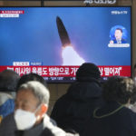 Ľudia sledujú na televíznej obrazovke zábery vypálenia rakety Severnou Kóreou.