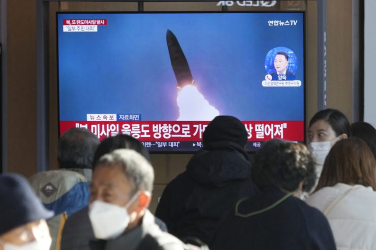 Ľudia sledujú na televíznej obrazovke zábery vypálenia rakety Severnou Kóreou.