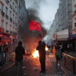 Kurdi mávajú vlajkou pri horiacej barikáde počas potýčok s políciou v centre Paríža