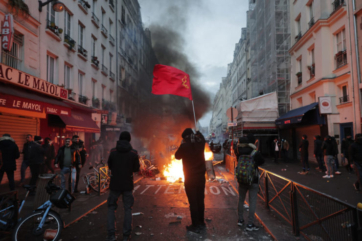 Kurdi mávajú vlajkou pri horiacej barikáde počas potýčok s políciou v centre Paríža