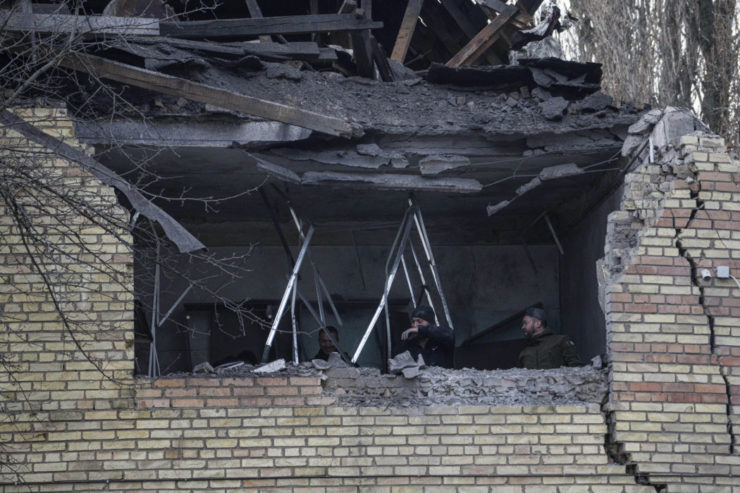 Muži kontrolujú materiálne škody na budove