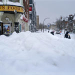 Ľudia kráčajú okolo obchodu po extrémnej snehovej búrke v americkom meste Buffalo v pondelok 26. decembra 2022.