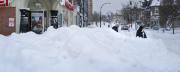 Ľudia kráčajú okolo obchodu po extrémnej snehovej búrke v americkom meste Buffalo v pondelok 26. decembra 2022.