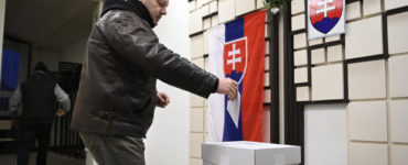 Volič vhadzuje obálku z hlasovacím lístkom do volebnej schránky krátko po otvorení volebnej miestnosti v Trenčianskych Stankovciach.