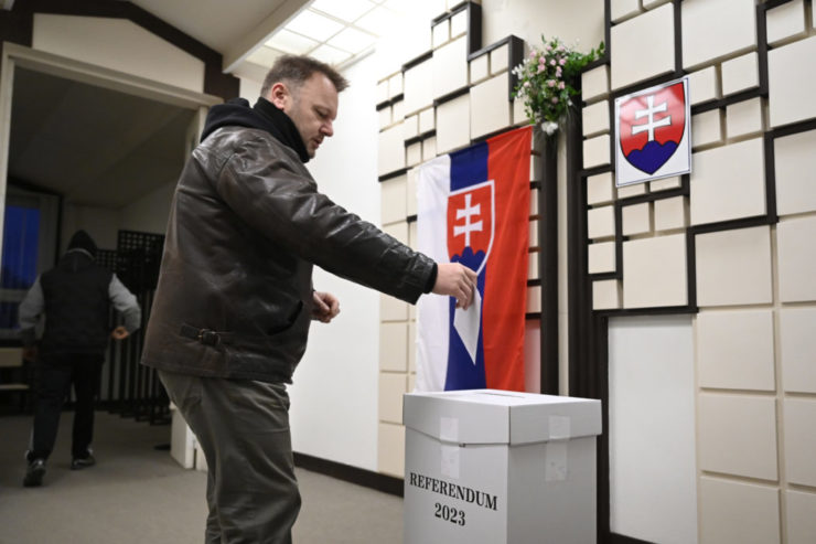 Volič vhadzuje obálku z hlasovacím lístkom do volebnej schránky krátko po otvorení volebnej miestnosti v Trenčianskych Stankovciach.