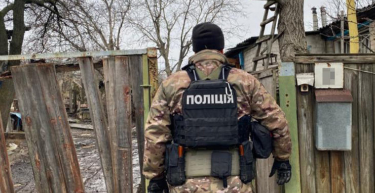 Na archívnej snímke ukrajinský policajt v Charkovskej oblasti dokumentuje následky ostreľovania