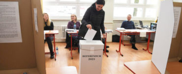 Žena vhadzuje obálku s hlasovacím lístkom do volebnej schránky vo volebnej miestnosti v Gymnáziu Park mládeže v Košiciach 21. januára 2023.