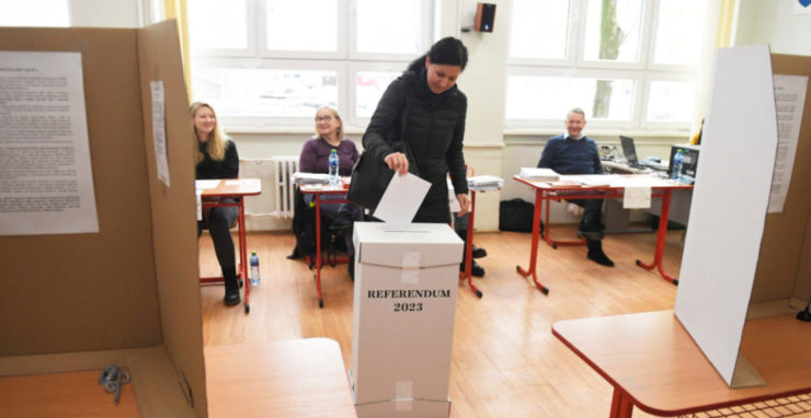 Žena vhadzuje obálku s hlasovacím lístkom do volebnej schránky vo volebnej miestnosti v Gymnáziu Park mládeže v Košiciach 21. januára 2023.