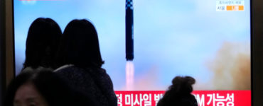 Ľudia sledujú televízne správy na železničnej stanici v Soule 18. februára 2023.