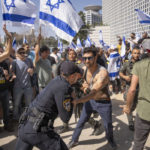 Izraelský policajt sa bije s demonštrantmi, ktorí sa pokúšajú blokovať hlavnú cestu počas protestu proti vládnemu návrhu súdnej reformy nového premiéra Benjamina Netanjahua v Tel Avive.