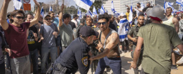 Izraelský policajt sa bije s demonštrantmi, ktorí sa pokúšajú blokovať hlavnú cestu počas protestu proti vládnemu návrhu súdnej reformy nového premiéra Benjamina Netanjahua v Tel Avive.