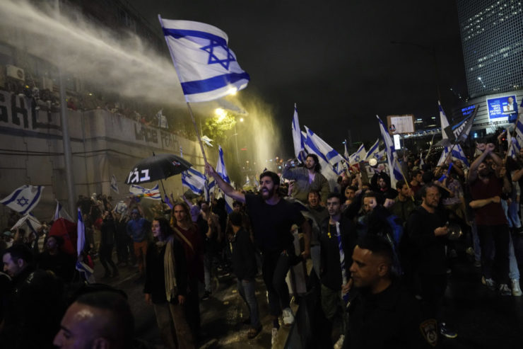 Izraelskí policajti zasahujú vodným delom na rozohnanie izraelských demonštrantov, ktorí blokujú diaľnicu počas protestu proti vládnemu návrhu súdnej reformy izraelského premiéra Benjamina Netanjahua v Tel Avive 25. marca 2023.