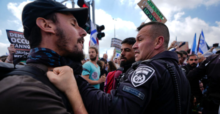 Izraelčania počas kolízie s políciou v rámci protestu proti vládnemu návrhu súdnej reformy izraelského premiéra Benjamina Netanjahua v Tel Avive 27. marca 2023.