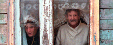 Na archívnej fotografii obyvatelia Južno-Kuriľska, najväčšieho mesta na sporných Kurilských ostrovoch, vyzerajú z okna svojho domu poznačeného extrémne chladným podnebím.