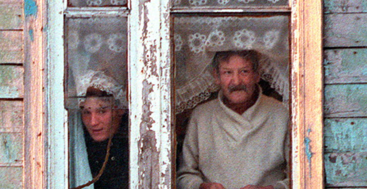 Na archívnej fotografii obyvatelia Južno-Kuriľska, najväčšieho mesta na sporných Kurilských ostrovoch, vyzerajú z okna svojho domu poznačeného extrémne chladným podnebím.
