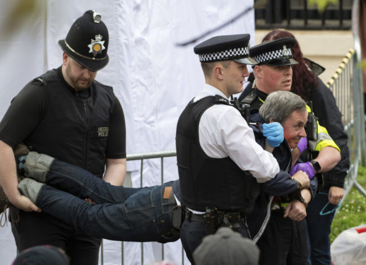 Policajti odnášajú zatknutého demonštranta zo zoskupenia Just Stop Oil pred korunováciou britského kráľa Karola III. a jeho manželky Kamily v Londýne v sobotu 6. mája 2023. FOTO TASR/AP