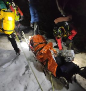 Záchranári pomáhajú zranenému skialpinistovi.