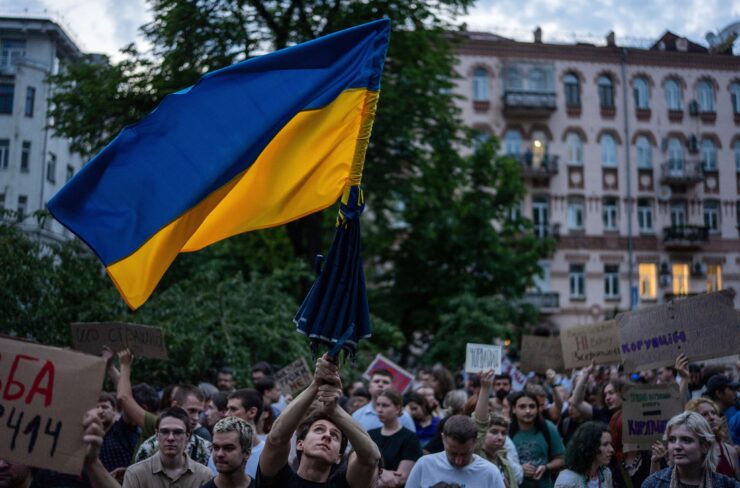 Demonštrant máva ukrajinskou zástavou počas protestu proti zákonu obmedzujúcemu autonómiu protikorupčných úradov v Kyjeve